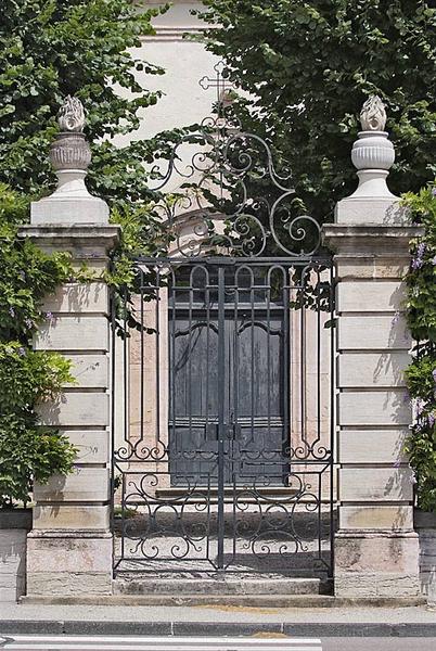 Porte principale à travers la grille du portail de la cour.