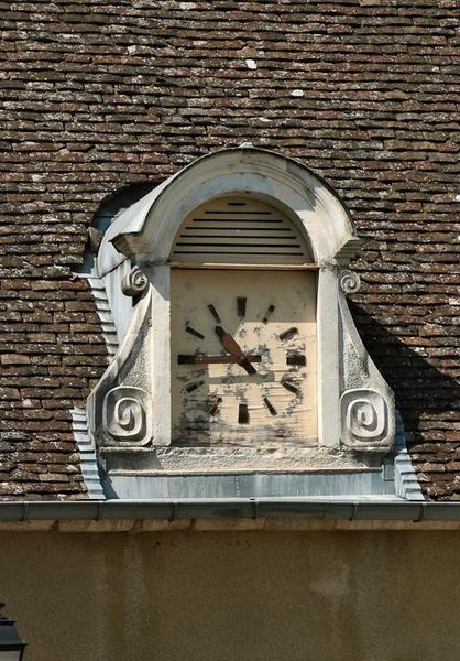 Corps de bâtiment au fond de la cour gauche : lucarne devenue horloge.