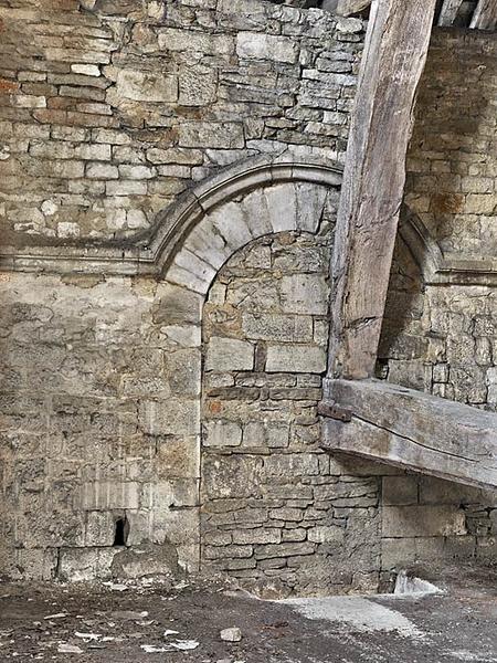 Ancienne chapelle : pièce aménagée à l'étage ; baie obturée.