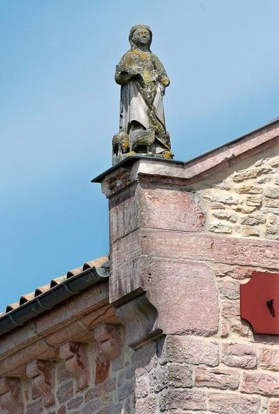 L'élévation de la façade présente une statue féminine (sainte Agnès ?) en amortissement à gauche.