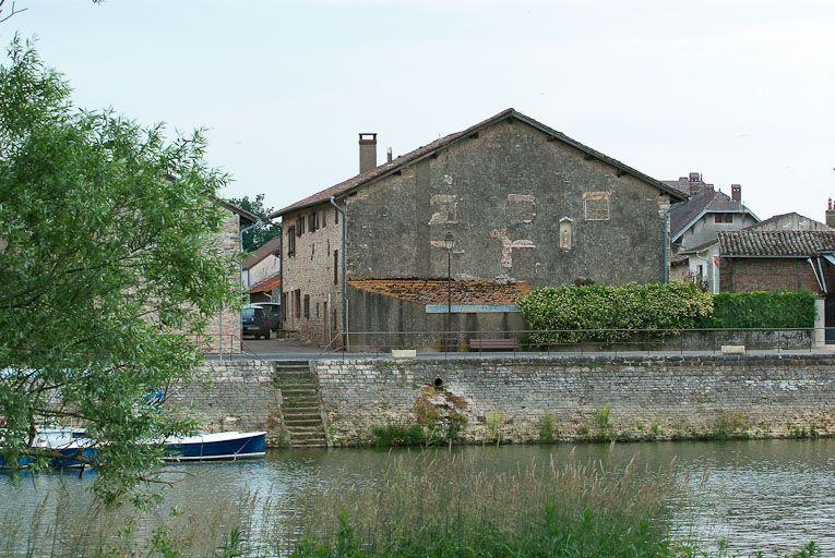 Vue d'ensemble d'une maison (pignon nord) avec Vierge à l'Enfant dans une niche, face aux quais de la Seille. La Seille au premier plan.