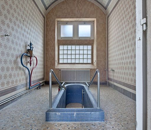 Corps central, salle de bain à droite du couloir du cabinet du médecin.