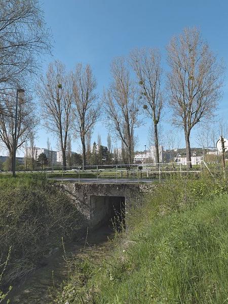 Déversoir du canal : en arrière-plan, le canal, puis les vannes du déversoir, le pont sur chemin de halage enjambant la rigole d'amenée de l'eau.