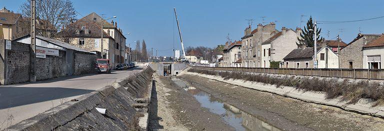 La traversée du canal à Dijon : habitations et locaux professionnels en bordure du canal. Le bief est vide pour permettre la réfection du pont sur l'écluse 55.