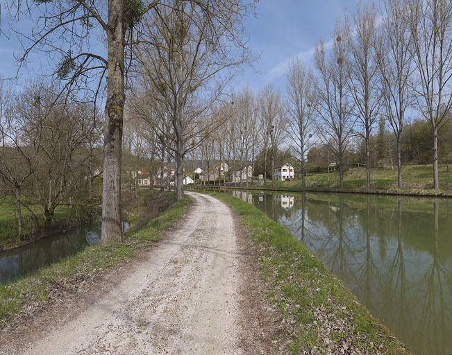 Passage du canal dans la vallée de l'Ouche : l'Ouche, le chemin de halage, au fond : le site d'écluse 25 et le canal avec un alignement d'arbres de chaque côté.