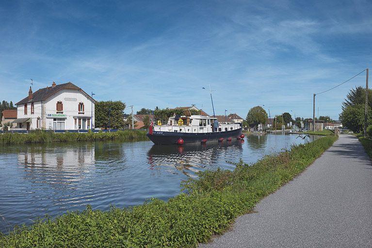 Vue d'amont des petits commerces installés le long du canal du Centre, dont le café de la mairie.