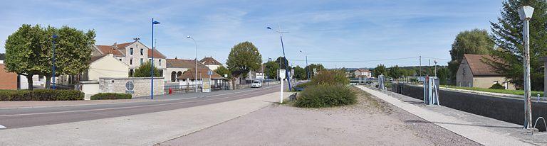 Vue d'ensemble prise d'amont de la mairie. Au fond, le monument aux morts. A droite, site d'écluse 04 avec maison.