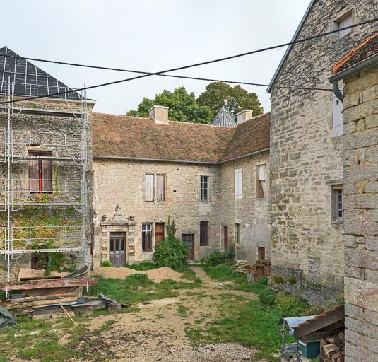 La cour avec une porte monumentale.