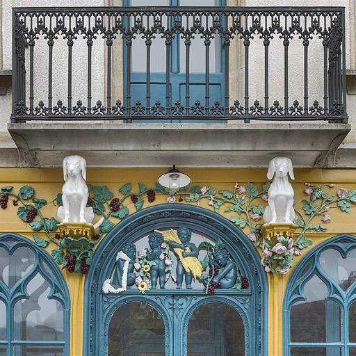 Vue rapprochée des deux chiens, au-dessus de la porte d'entrée de la façade.