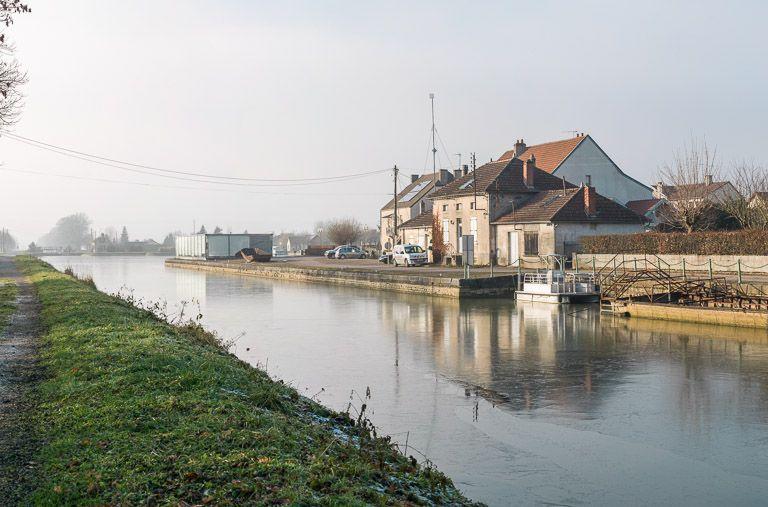 Vue d'amont. En arrière plan le centre d'interprétation et le port.