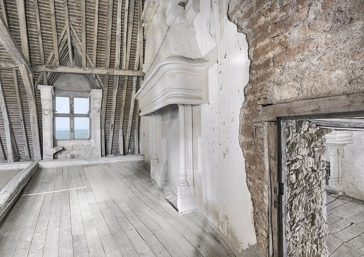 Combles : au-dessus du grand logis, partie droite. Mur de séparation avec la tour carrée. Cheminée et fenêtre à montants sculptés.