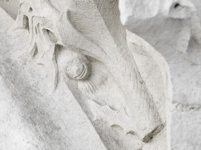 Logis des Hôtes : détail d'un animal sculpté dans les moulures de la porte d'entrée principale, à droite.