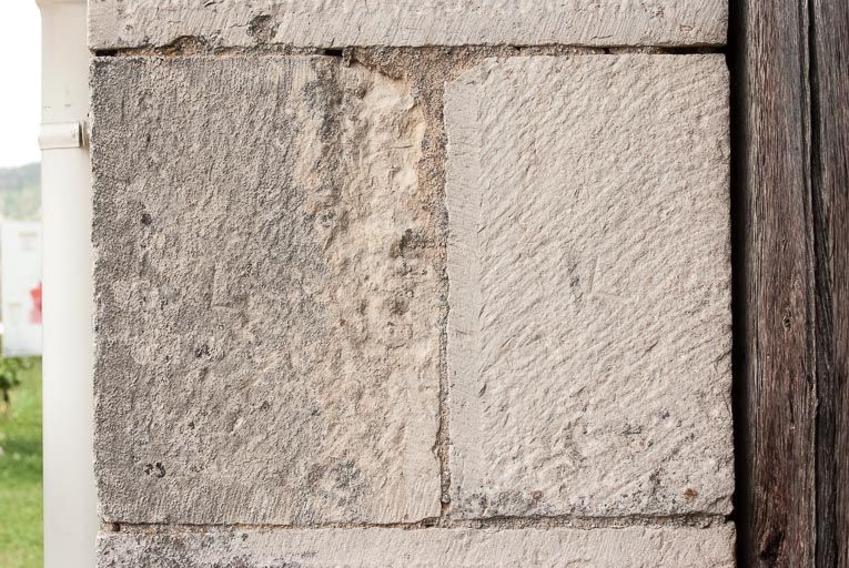 Marque de tâcheron sur la porte charretière à l'ouest de l'édifice.