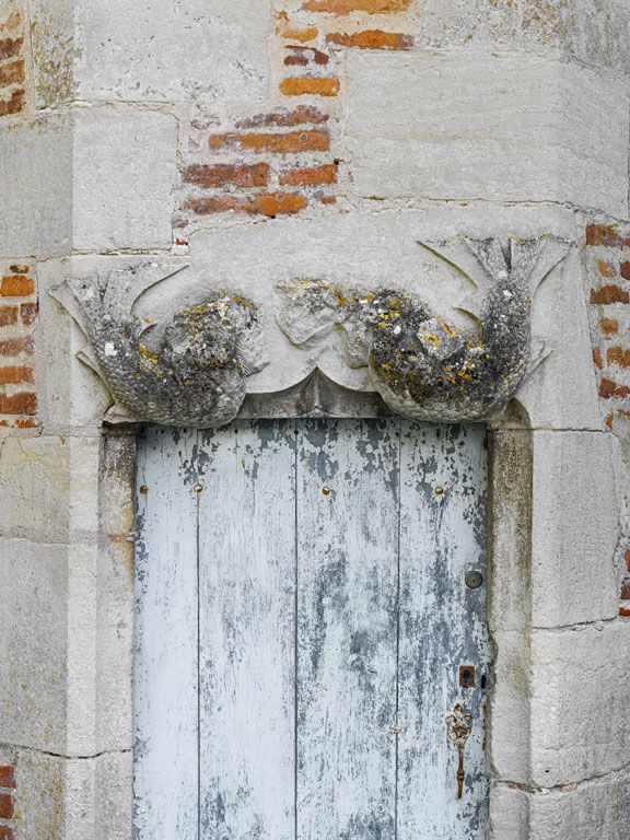 Porte de la tourelle d'escalier : détail des sirènes sur le linteau.