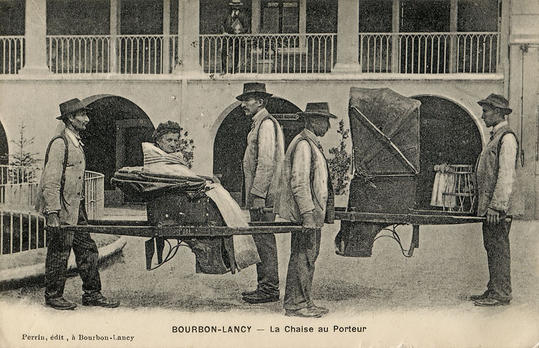 Femme sur une chaise à porteurs dans la cour de l'établissement thermal (premier quart du 20e siècle).
