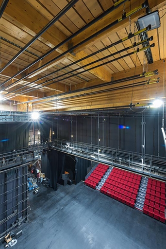 Théâtre : vue plongeante sur la scène et la salle, montrant les passerelles et la charpente.