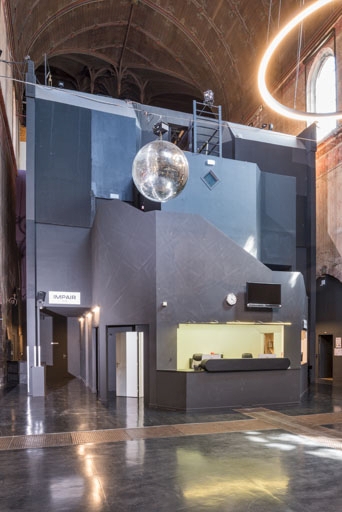 Entrée de la nef, avec la billetterie du théâtre, vue de trois quarts. Le concept de "boîte dans la boîte" est clairement lisible.
