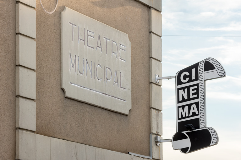 Façade latérale gauche en 2022, avant transformation : inscription Théâtre municipal et enseigne du cinéma.