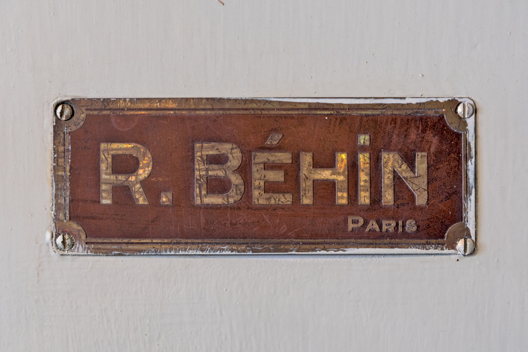 Salle des archives, étagères, plaque de firme (R. Béhin, Paris).