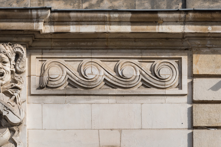 Façade antérieure : partie supérieure avec décor de postes.