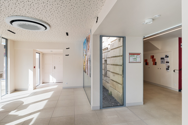Vestibule. La partie basse de la façade est visible au centre, l'accueil est à droite.