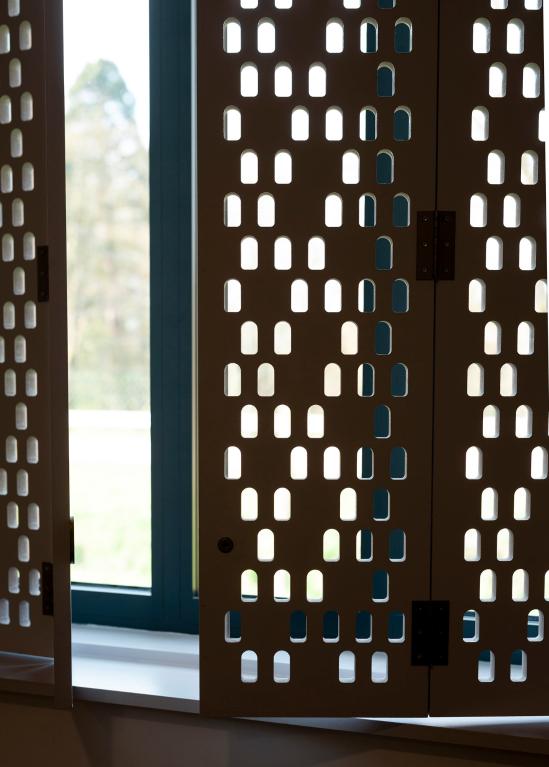 Bâtiment après reconversion : Pôle de santé libéral et ambulatoire (PSLA), détail des volets intérieurs, motif perforé.