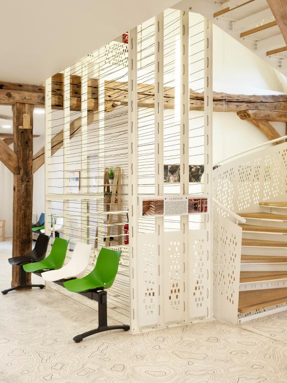 Bâtiment après reconversion : Pôle de santé libéral et ambulatoire (PSLA), structure évoquant les supports du séchoir à bois déroulé.