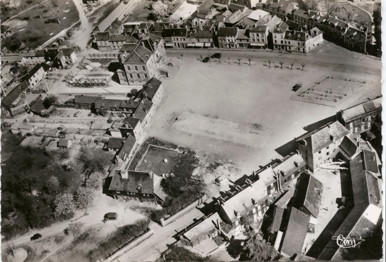 Vue aérienne de la place du Général de Gaulle : la halle au grains détruite et les dernières traces de la mare communale.- Carte postale, [vers 1950], Cim éditeur. (Collection mairie de Routot).