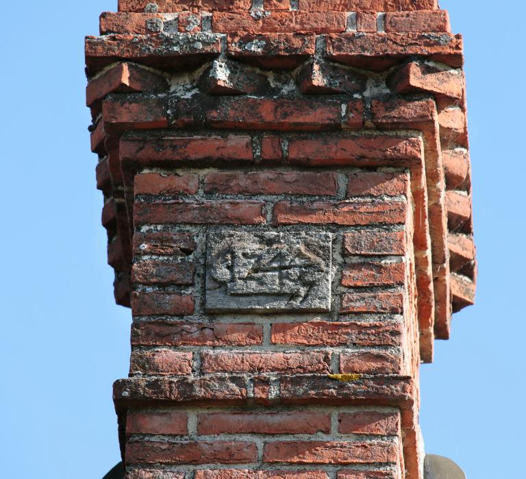 Logis du fermier, détail de la cheminée et du cartouche daté.