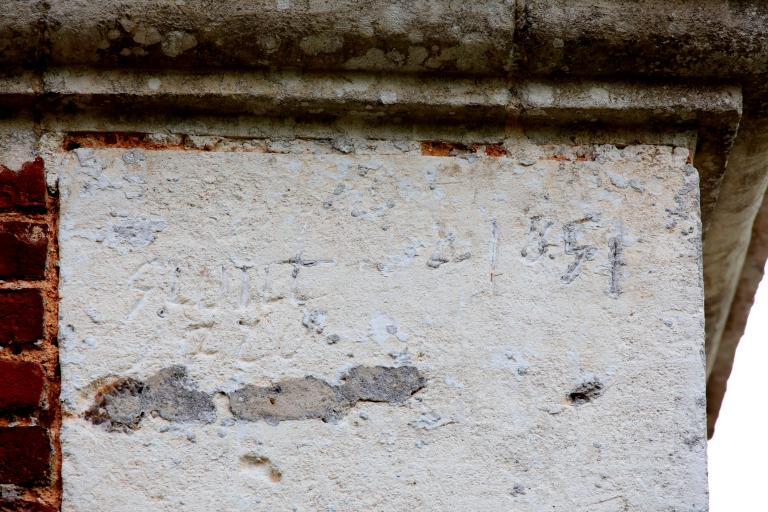 Pignon nord, détail d'une inscription gravée au sommet du chaînage d'angle. 
