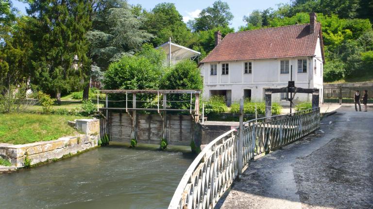 Vannes de décharge au premier plan, bureau et logement à l'arrière plan.