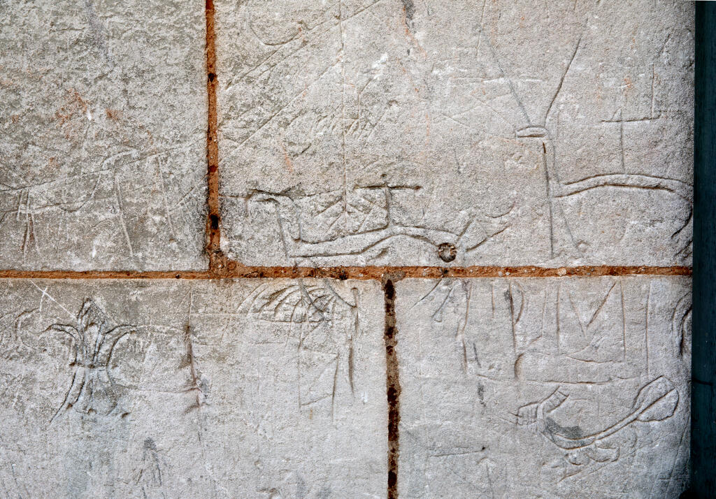 Graffiti gravés sur les murs extérieurs et sous le porche de l'église.