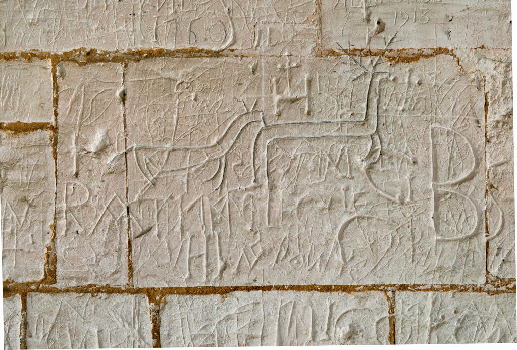 Graffiti gravés sur les murs extérieurs et sous le porche de l'église.