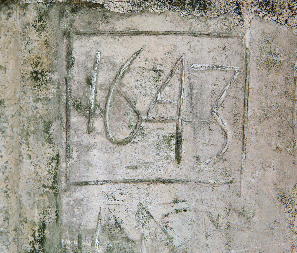 Graffiti gravés sur les murs extérieurs et sous le porche de l'église.