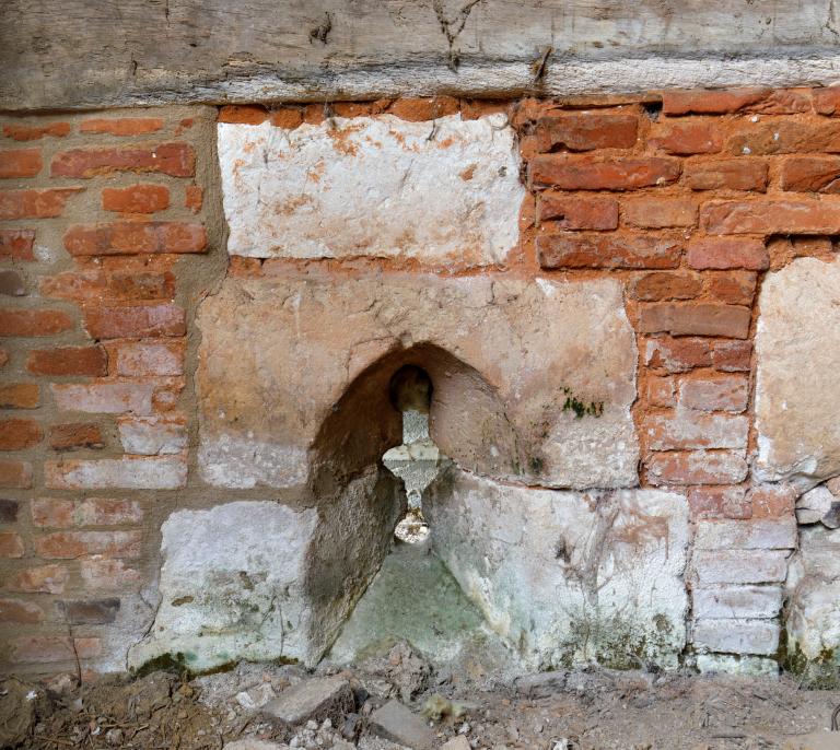 Grange et pressoir, détal d'un soupirail avec pierre de taille en remploi. 