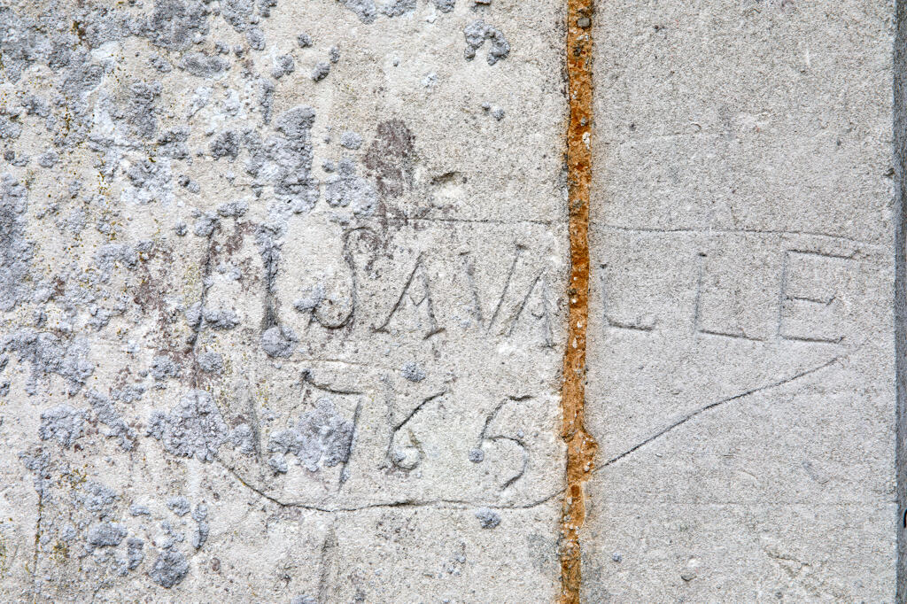 Graffiti gravés sur les murs extérieurs et sous le porche de l'église.