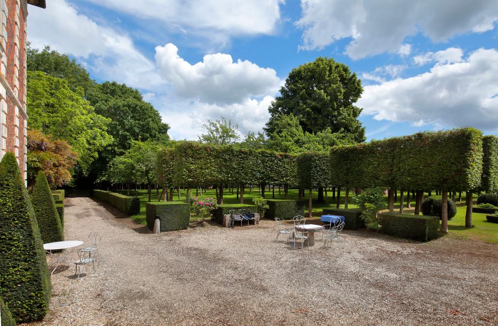 Bosquet et allées de tilleuls taillés à l'avant du château, côté est. 