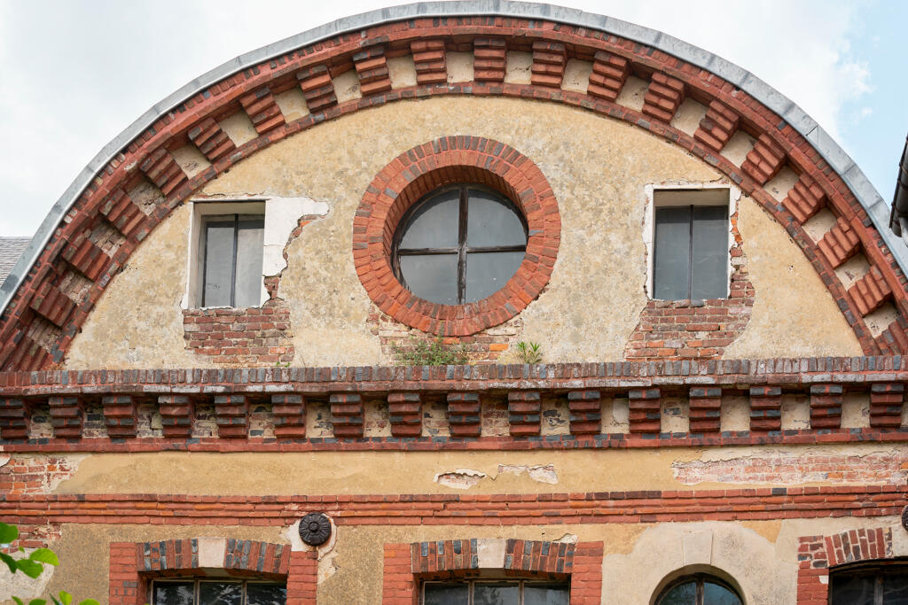 Atelier de filature, vue de l'est : détail du fronton arrondi.