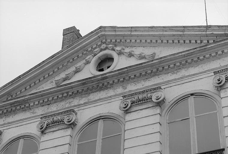 Façade sur rue, détail : décor sculpté des pilastres et du fronton.