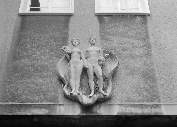Sculpture située au-dessus du passage couvert : couple nu.