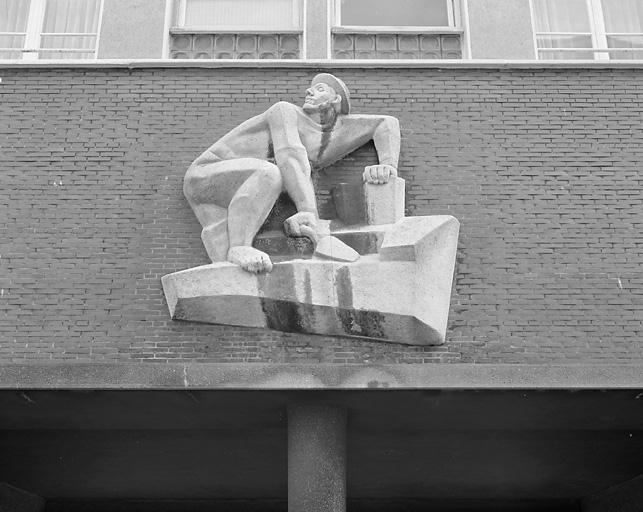 Sculpture située au-dessus du passage couvert : maçon.