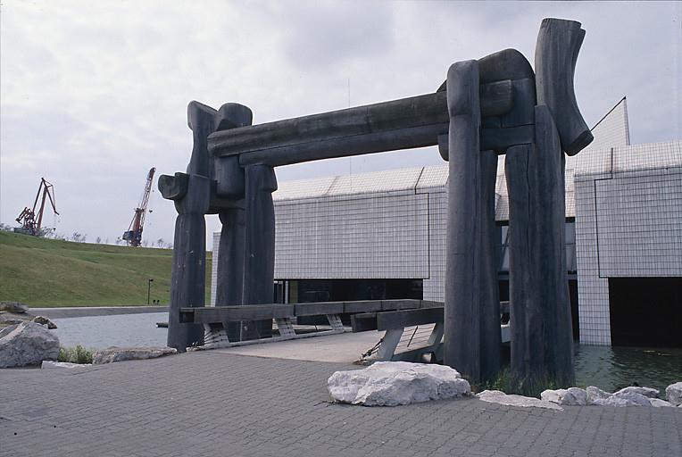 Détail : entrée précédée d'un pont et d'un portail monumental.