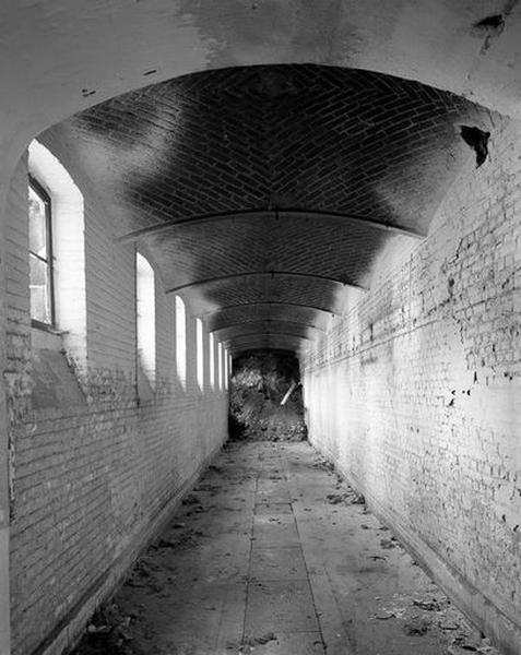 Passage voûté souterrain situé sous la galerie de service bordant le côté sud de la cour d'honneur, vue en enfilade.