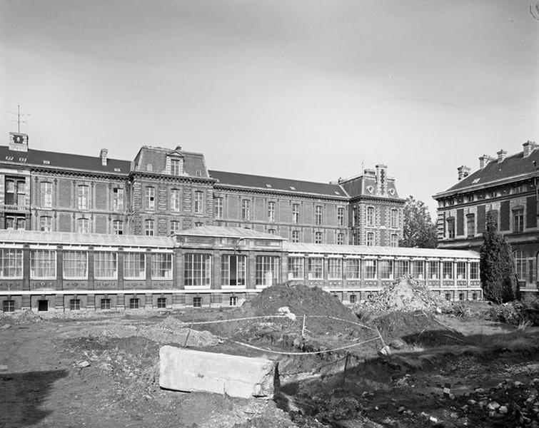 Cour d'honneur, vue générale montrant, au premier plan, l'une des galeries de service longitudinales et, en arrière-plan, la moitié est du bâtiment des malades flanquant la cour au nord.