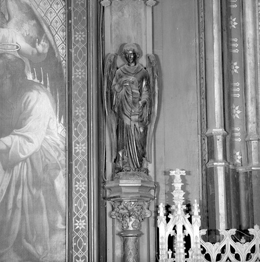 Vue de détail d'une statue représentant un ange tenant un phylactère.