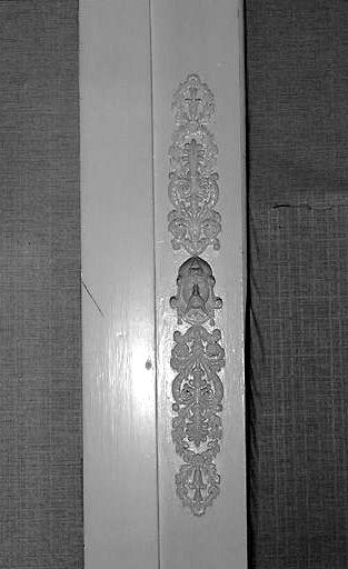 Intérieur, rez-de-chaussée, pièce sud-ouest, trumeau de cheminée, détail : jouxtant le pilastre de gauche, un visage de Gaulois.