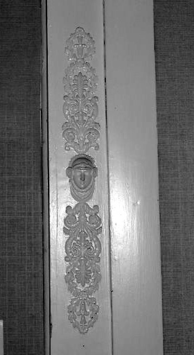 Intérieur, rez-de-chaussée, pièce sud-ouest, trumeau de cheminée, détail : jouxtant le pilastre de gauche, un visage de femme.