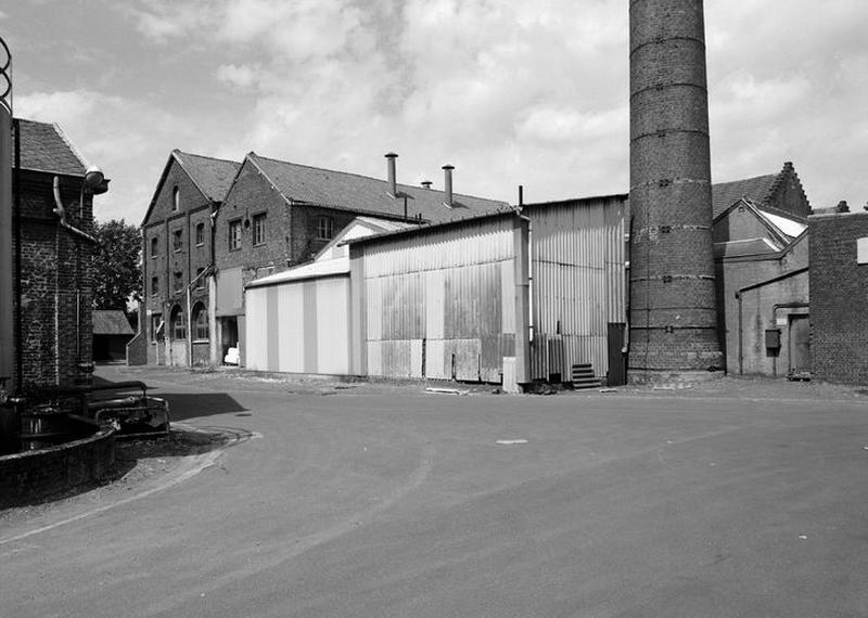 Vue intérieure de la cour, bâtiments industriels et cheminée.