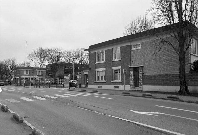 Entrée principale de l'établissement encadrée de deux pavillons, celui de gauche servant de conciergerie, celui de droite (qui a été l'objet d'une extension) de bureau d'informations et de logement, élévation antérieure, vue prise de trois-quarts droit.