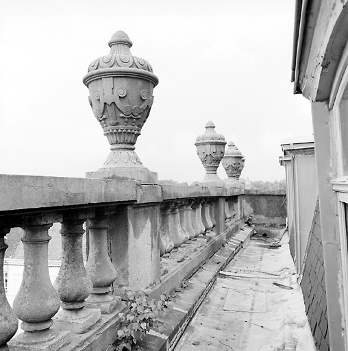 Façade : balustrade ornée de vases de pierre et chéneau devant le comble, vue en enfilade.